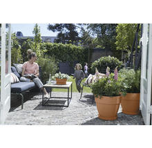 Tuin met terras, zithoek, tafel en beplante bloempotten voor buiten