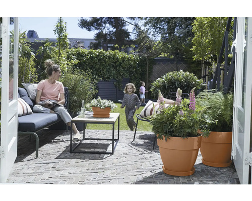 Tuin met terras, zithoek, tafel en beplante bloempotten voor buiten