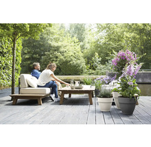 Tuinmeubelset met planten en ontspannen mensen op een terras
