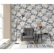Woonkamer met bloemenbehang, fauteuil, vloerlamp en tafel