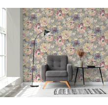 Woonkamer met bloemenbehang, fauteuil, vloerlamp en bijzettafel