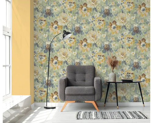 Woonkamer met bloemenbehang, fauteuil, vloerlamp en bijzettafel