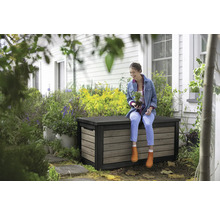 Vrouw zit op een weerbestendige opbergbox in de tuin