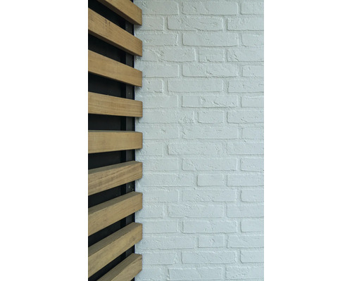 Decoratieve houten bekleding naast een muur met metselwerklook.
