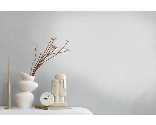 Decoratieve stillevenopstelling met kaars, vaas, decoratie, klok en beeldjes.