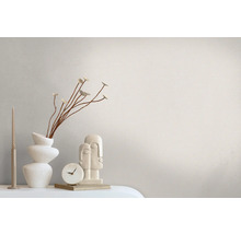 Decoratief stilleven met kaars, vaas, bloemtak, klok en sculptuur op een tafel