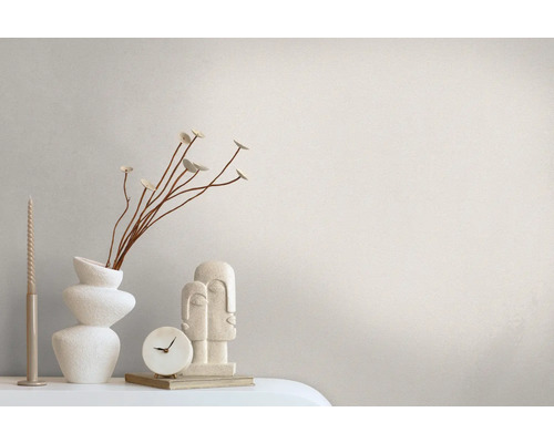 Decoratief stilleven met kaars, vaas, bloemtak, klok en sculptuur op een tafel