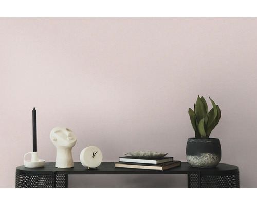 Decoratieve scène met kaars, beeld, klok, boeken en potplant op een zwarte plank