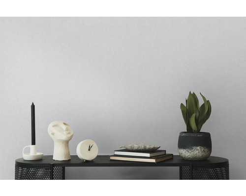 Decoratieve schikking met kaars, sculptuur, klok, boeken en potplant op een zwarte tafel