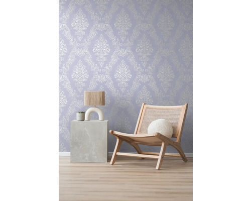 Decoratief behang met ornamentpatroon in de woonkamer met lamp en fauteuil