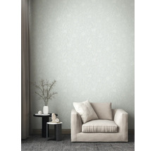 Woonkamer met patroonbehang, fauteuil en bijzettafels