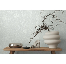 Decoratief stilleven met bloemenbehang op de achtergrond, gearrangeerd op een houten tafel.