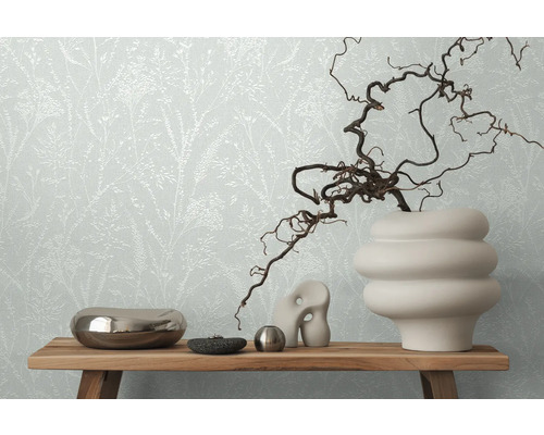 Decoratief stilleven met bloemenbehang op de achtergrond, gearrangeerd op een houten tafel.