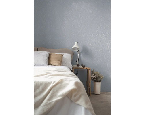 Slaapkamer met behang met bloemenpatroon, bed en nachtkastje