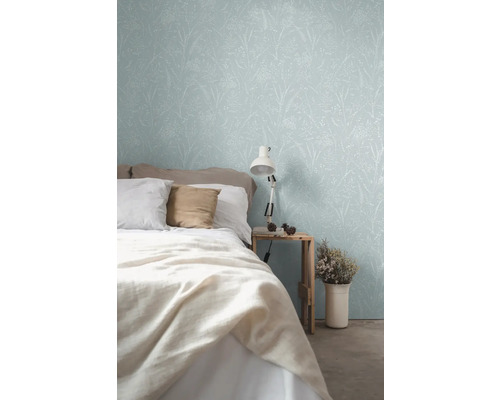 Slaapkamer met behang met bloemmotief, bed en nachtlamp