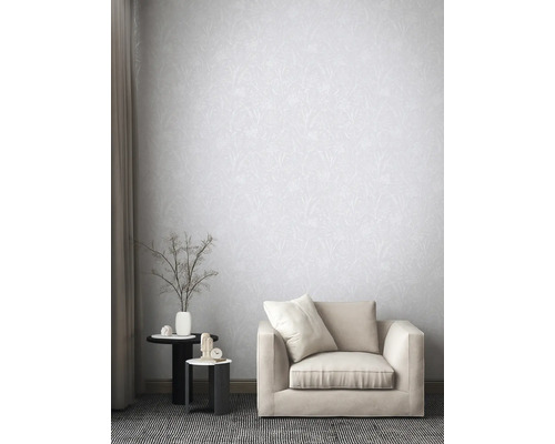 Woonkamer met patroonbehang, fauteuil en bijzettafels