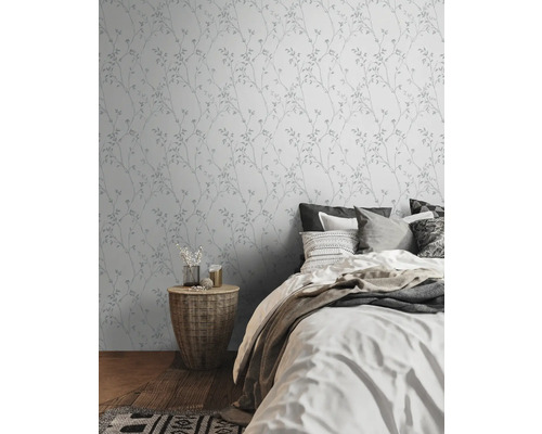 Slaapkamer met wandbehang met plantenmotief en tweepersoonsbed.