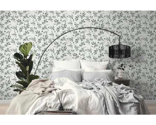 Slaapkamer met bloemenbehang, bed en staande lamp