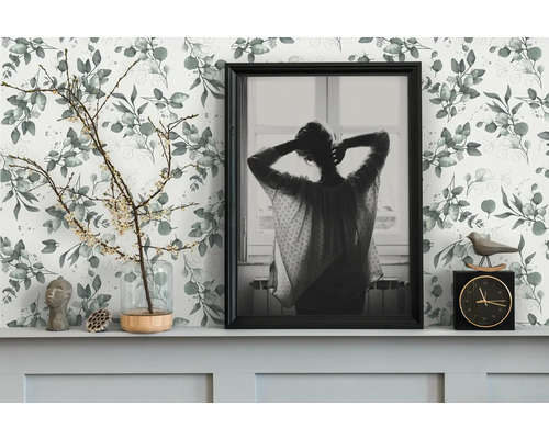 Decoratief interieur met een behang met print, een ingelijste foto en decoraties op een plank
