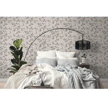 Slaapkamer met behangmotief, bed en staande lamp