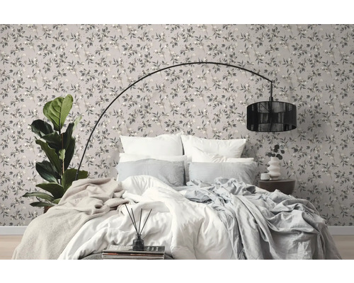 Slaapkamer met behangmotief, bed en staande lamp