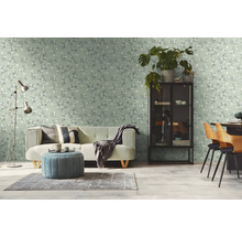 Lichte woonkamer met een bank, een fauteuil en een patroonbehang.