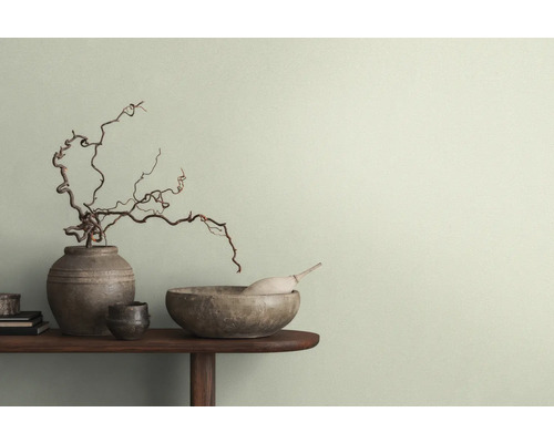 Decoratieve scène met vazen, schalen en takken op een tafel voor een muur