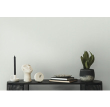 Decoratieve scène met kaars, beeld, klok, boeken en potplant op een zwarte tafel