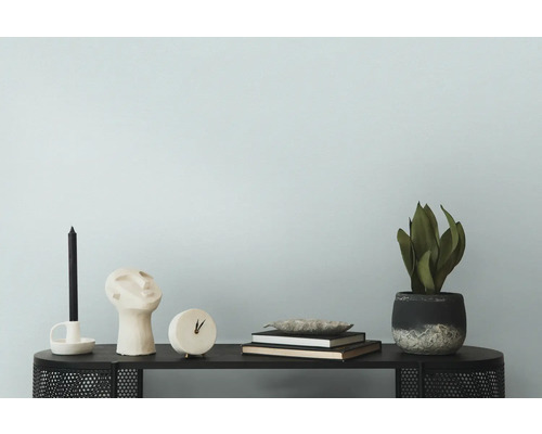 Decoratieve opstelling met kaars, beeld, klok, boeken, schaal en plant op een tafel