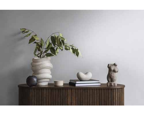 Decoratief arrangement op een houten kast met vaas, planten, boeken en sculpturen.