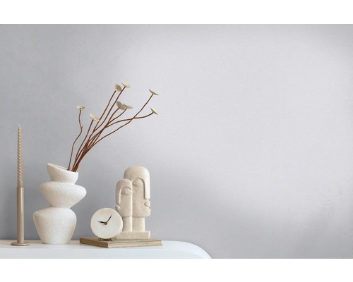 Decoratieve scène met vaas, droogbloemen, kaars, klok en sculptuur op een tafel.