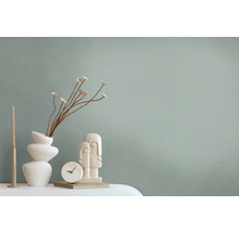 Decoratieve scène met een vaas, sierbloemen, een sculptuur, een klok en een kaars op een tafel