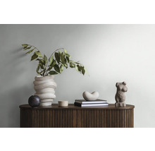 Decoratief interieur met houten dressoir, vaas met groene plant, boeken en sculpturen.