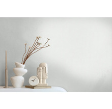 Decoratieve scène met vaas, sierbloemen, kaars, tafelklok en sculptuur op een tafel