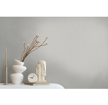 Decoratieve scène met vaas, sculptuur, klok en kaars op een tafel.
