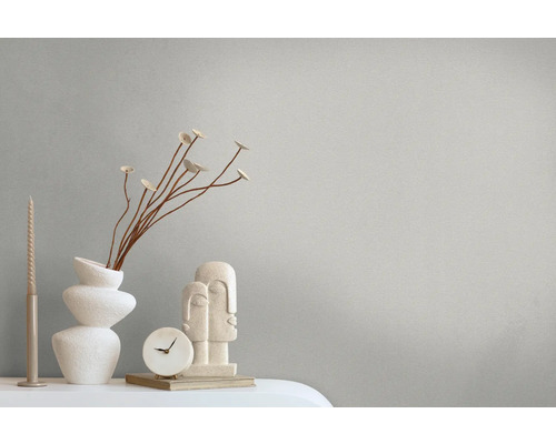 Decoratieve scène met vaas, sculptuur, klok en kaars op een tafel.