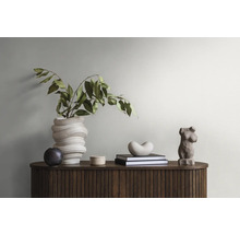 Decoratief arrangement met vaas, planten, boeken en beeldhouwwerken op een houten kast