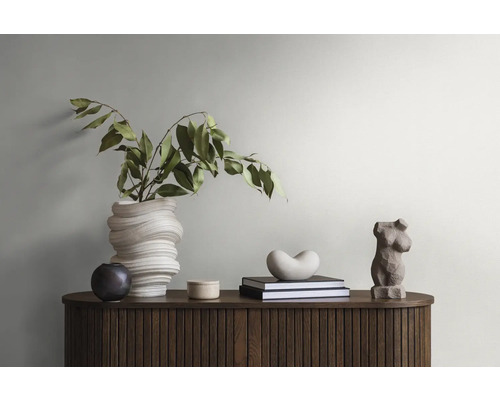 Decoratief arrangement met vaas, planten, boeken en beeldhouwwerken op een houten kast