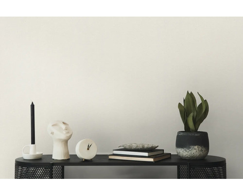 Decoratieve scène met kaars, sculptuur, klok, boeken en potplant op een console