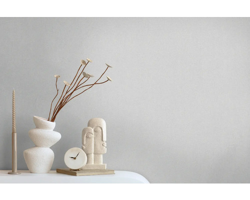 Decoratieve scène met vaas, decoratieobject, klok en kaars op een tafel.