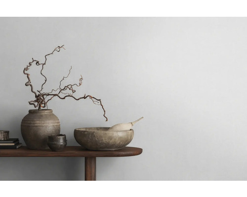 Decoratieve opstelling met schaal, vaas en takken op een houten tafel