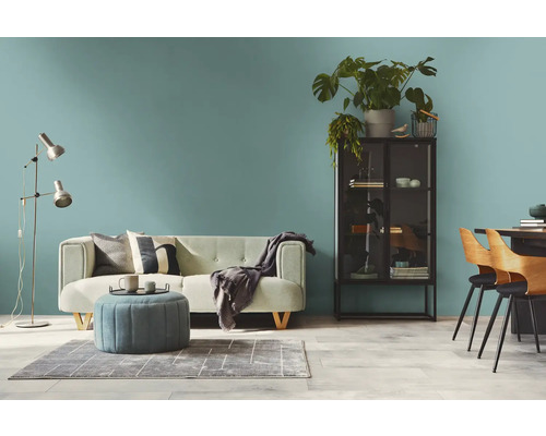 Woonkamer met bank, fauteuil, vloerlamp, kast en eettafel