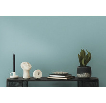 Decoratieve objecten zoals kaars, sculptuur, klok, boeken en plant op een tafel