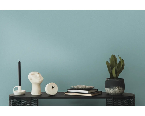 Decoratieve objecten zoals kaars, sculptuur, klok, boeken en plant op een tafel