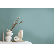Decoratieve scène met vaas, gedroogde bloemen, kaars, klok en sculptuur op een tafel.