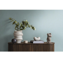 Decoratief interieur met vaas, beelden en boeken op een houten kast.
