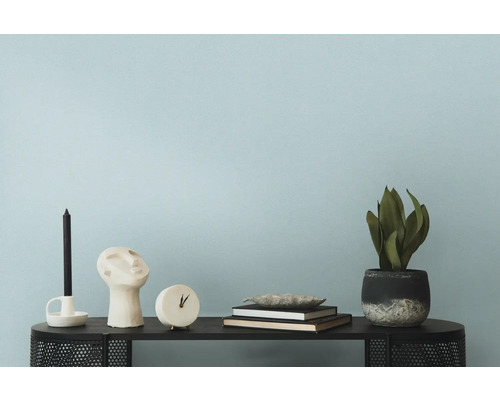 Decoratieve objecten zoals kaars, sculptuur, klok, boeken en kamerplant op een tafel