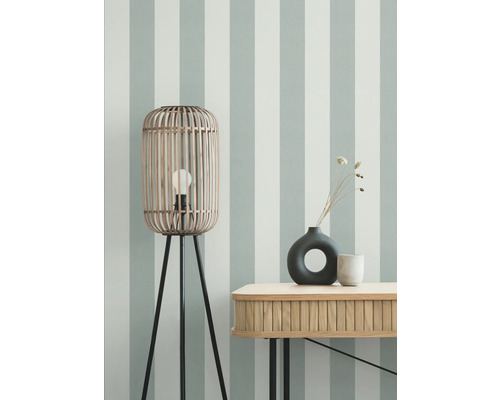 Kameroverzicht met houten vloerlamp, tafel en decoratie voor een gestreepte wand