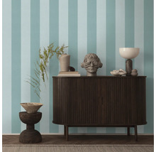 Woonkamer met gestreept behang, dressoir en decoratieve objecten.
