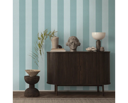 Woonkamer met gestreept behang, dressoir en decoratieve objecten.